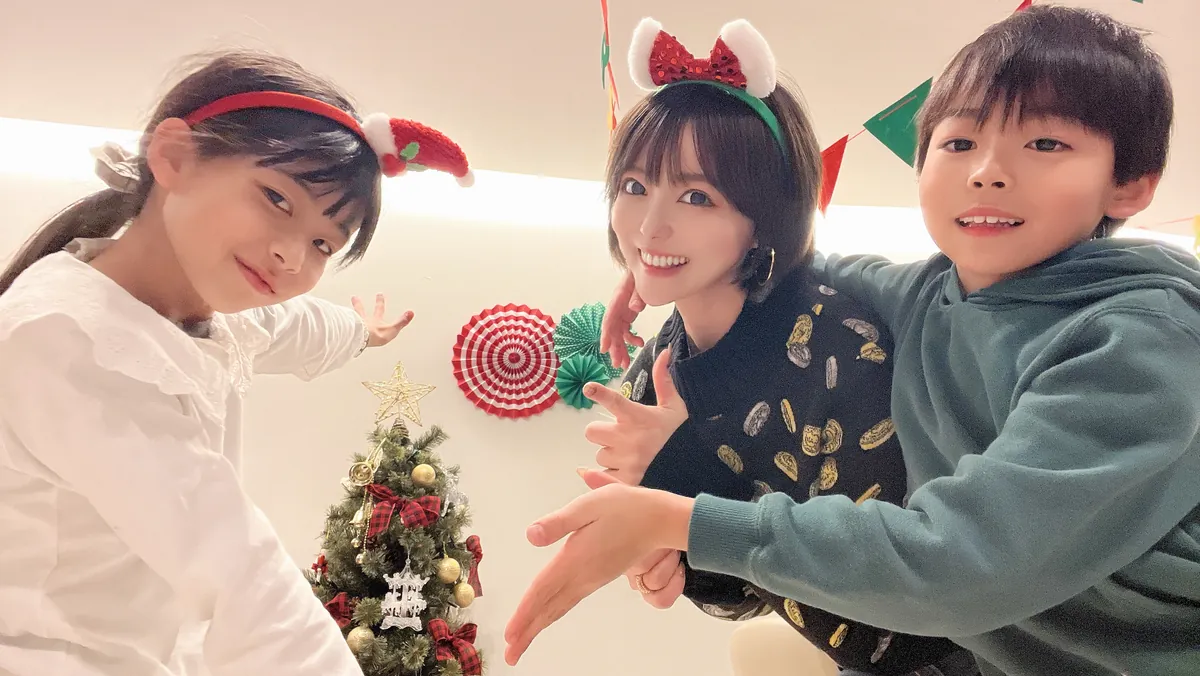 クリスマスの飾りの前で、子どもたちと一緒に笑顔で